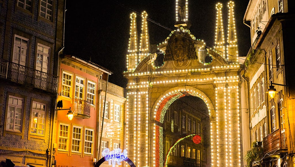 Braga in winter light: A city gate illuminated for the season. Calm, festive, and full of the gentle energy that travelers remember.