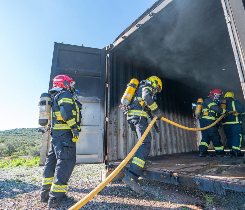 Bombeiros trainees enter simulated dwelling to extinguish fire