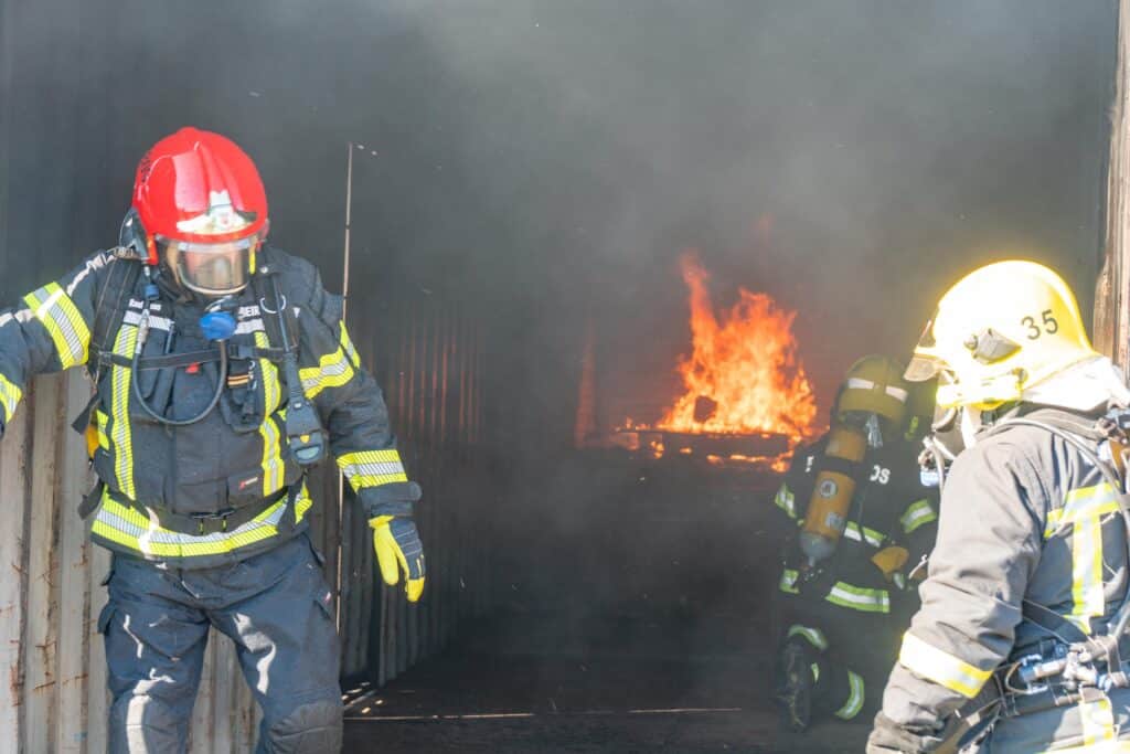 Bombeiros trainees extinguish fire in simulated dwelling