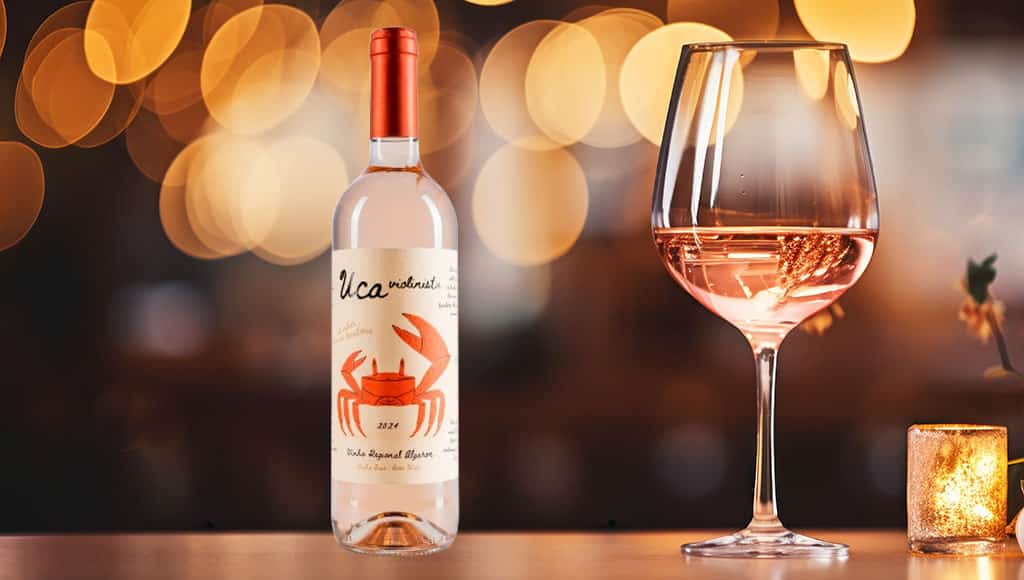 A glass of rosé wine on a table with a blurred restaurant background.
