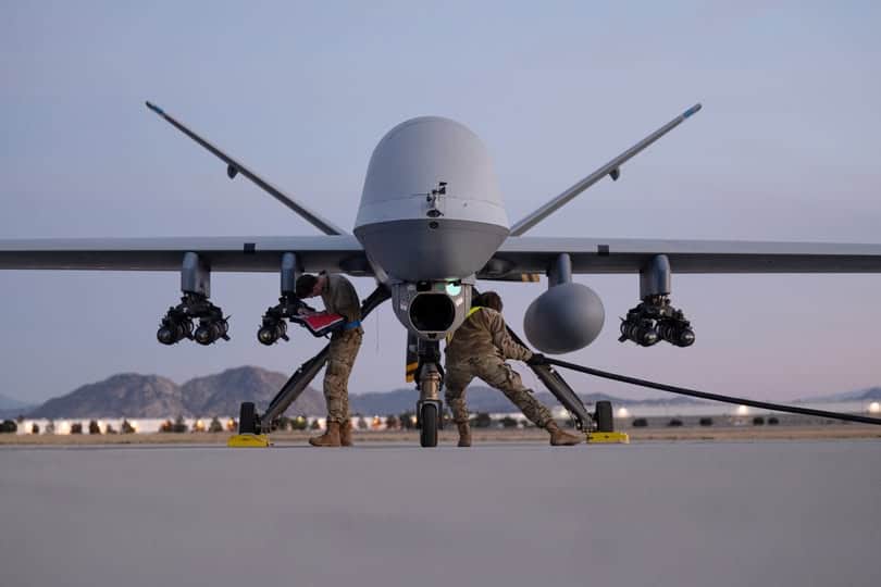 U.S. Air National Guard maintainers assigned to the 163d Attack Wing (ATKW) annotate AGM-114 Hellfire missile load and drag power supply cable to MQ-9 Reaper Aircraft on the hot cargo pad at March Air Reserve Base in California, Dec. 10, 2023. The U.S. Missile Defense Agency conducted a successful intercept of an Intermediate Range Ballistic Missile (IRBM) by an upgraded Ground-Based Interceptor (GBI). The test demonstrated the ability of the Ground-Based Midcourse Defense (GMD) capability to engage threats. Photo: Joseph Pagan | National Guard of the United States Air Force