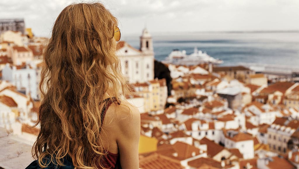 A landscape shot of a young female traveler enjoying the view in Alfama Lisbon Portugal