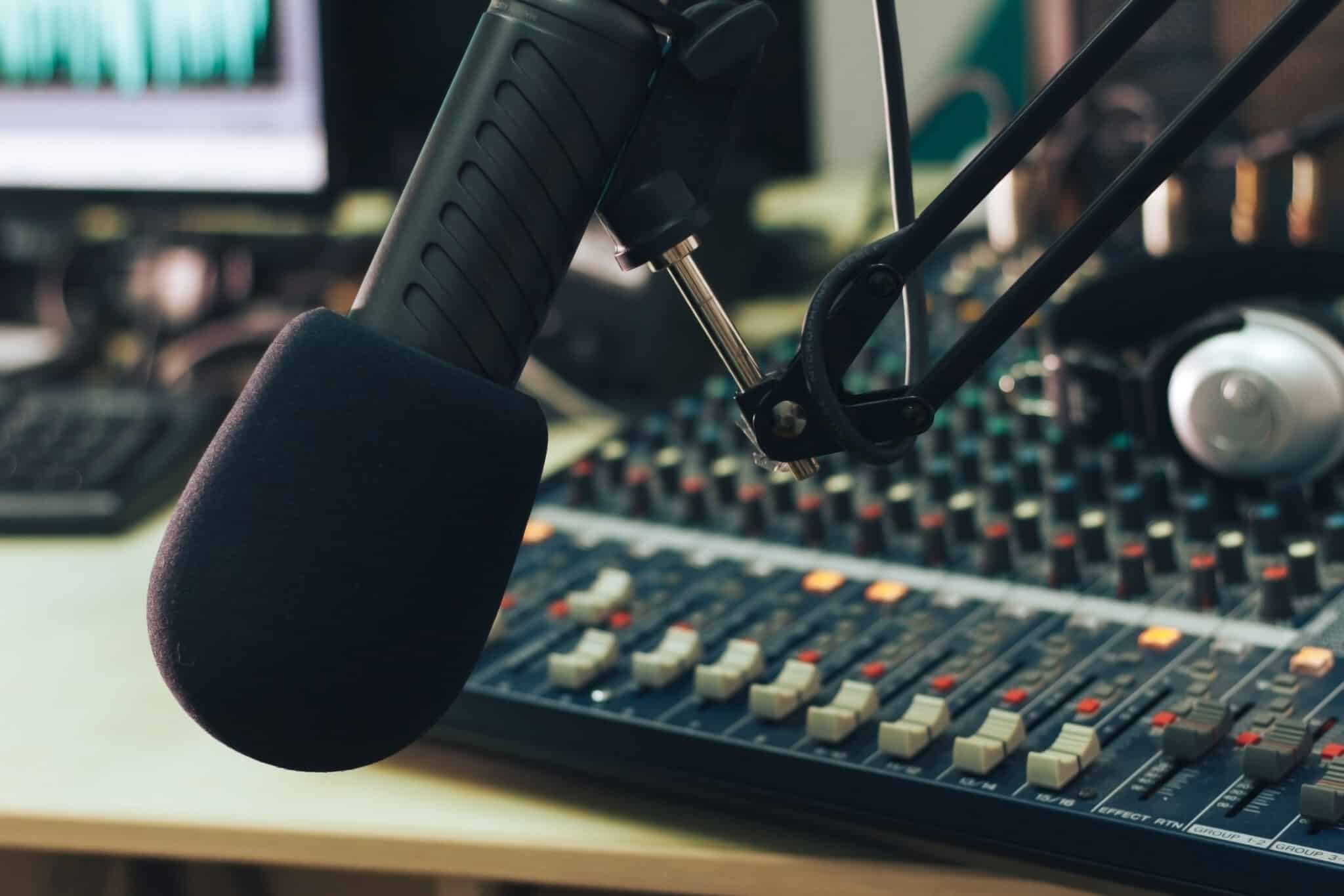 Radio host microphone, mixing console and headphones close-up